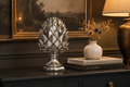 Silver artichoke ornament styled on a dark sideboard in a moody elegant room